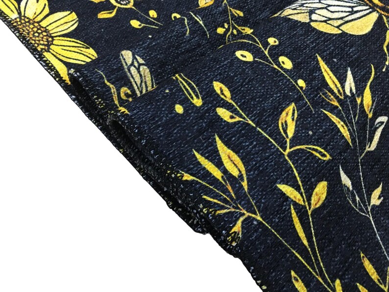 a close-up view of a black fabric with a yellow floral pattern.