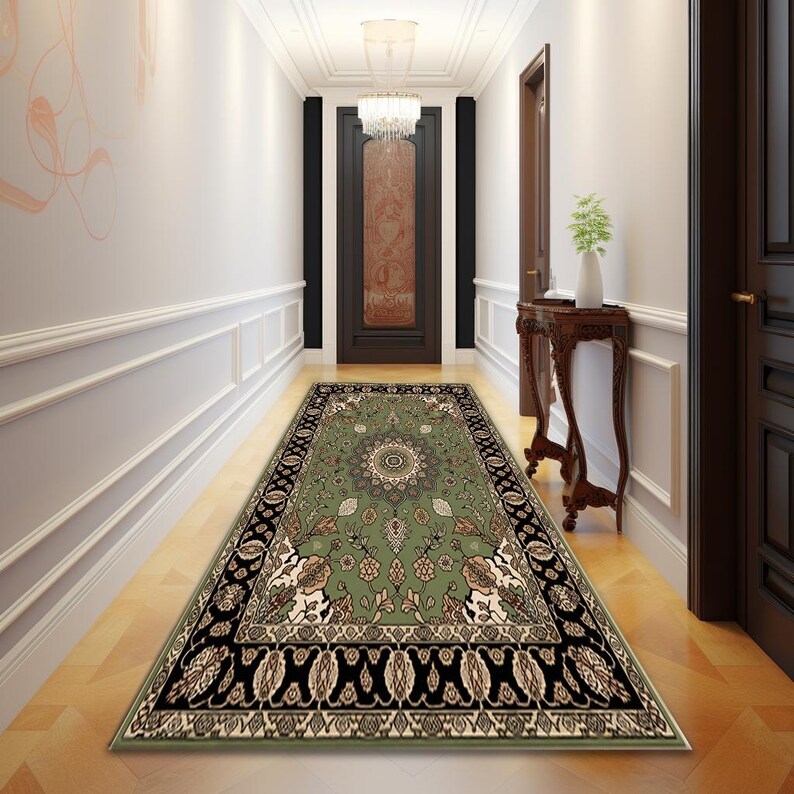 A hallway with a large, ornate rug on the floor, leading to a door with a chandelier above it. The hallway is decorated with a wooden table and a plant, creating a warm and inviting atmosphere.