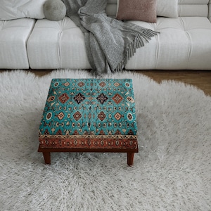 a cozy living room with a plush white rug, a white sofa, and a colorful patterned ottoman in the center of the room.