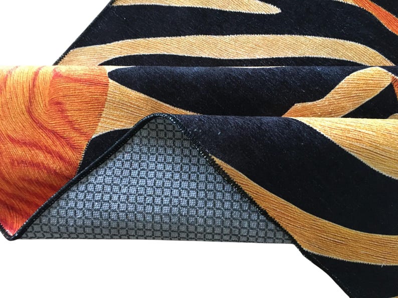 a close-up view of a colorful rug with a geometric pattern in shades of orange, black, and gray.