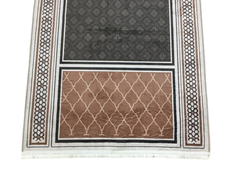 a rug with a geometric pattern and a darker geometric pattern on the lower half.