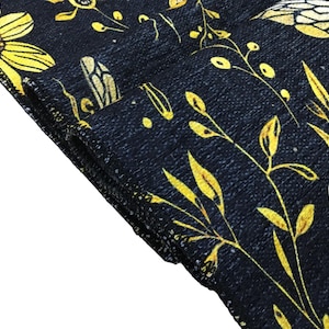 a close-up view of a black fabric with a yellow floral pattern.