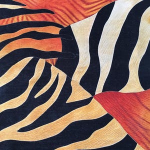 The image is a close-up of a textured surface with a striking pattern of black, orange, and white stripes and lines.