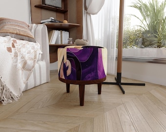 May include: A round ottoman featuring a vibrant purple and cream abstract wave pattern on its upholstered top. The base is constructed from dark brown wood and is supported by four short, tapered wooden legs that provide a stable foundation.