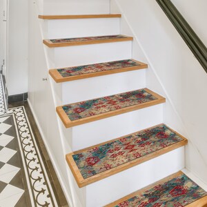 May include: A set of five patterned stair treads in shades of blue, red, and beige. The treads are placed on a set of white wooden stairs.