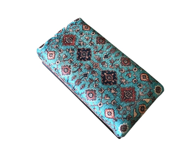 A colorful, patterned wallet or card case with a turquoise and brown color scheme, featuring intricate floral and geometric designs.