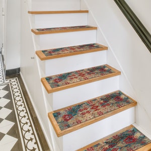 May include: A set of five patterned stair treads in shades of blue, red, and beige. The treads are placed on a set of white wooden stairs.