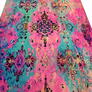 a vibrant, colorful rug with intricate patterns and designs in shades of pink, blue, green, and yellow.