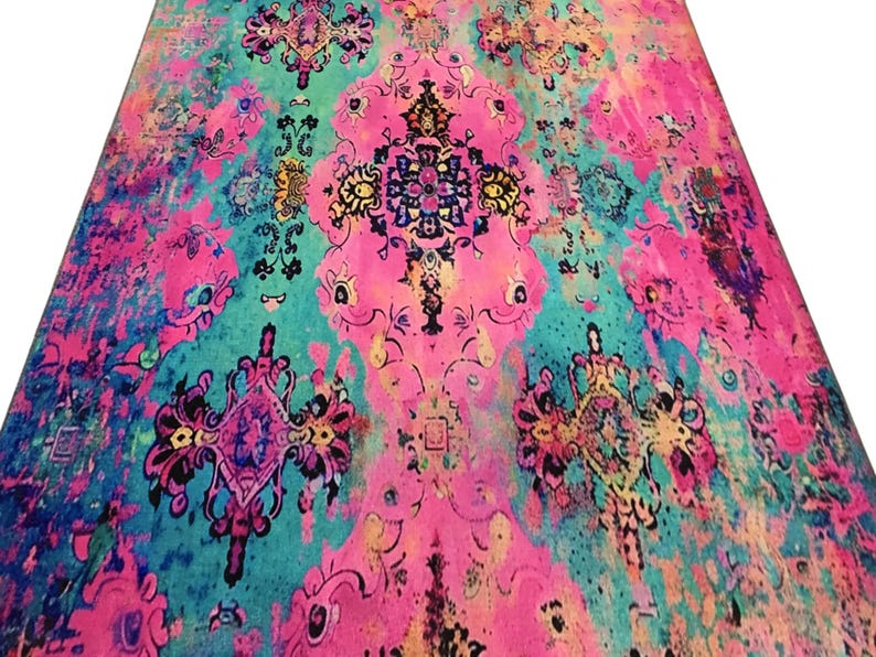 a vibrant, colorful rug with intricate patterns and designs in shades of pink, blue, green, and yellow.
