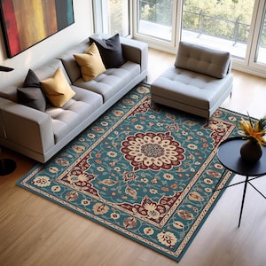 Pode incluir: Um tapete retangular com fundo turquesa e um medalhão floral central em bordô e creme. O tapete apresenta uma borda detalhada com padrões florais e de videira, adicionando um toque de elegância à sala de estar.
