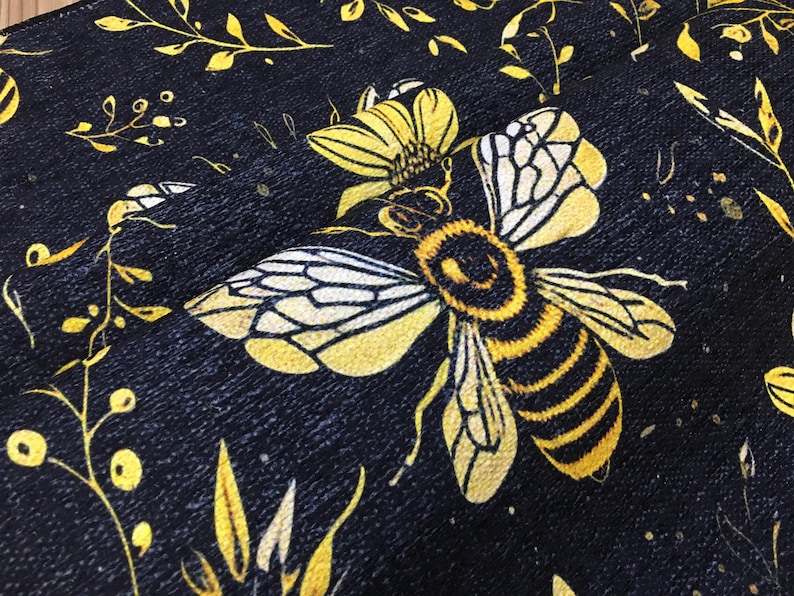 a close-up view of a detailed, colorful print of a bee on a black background.