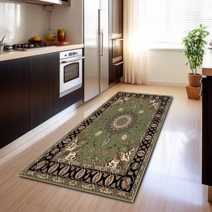 a kitchen with a rug on the floor, a potted plant, and a refrigerator.