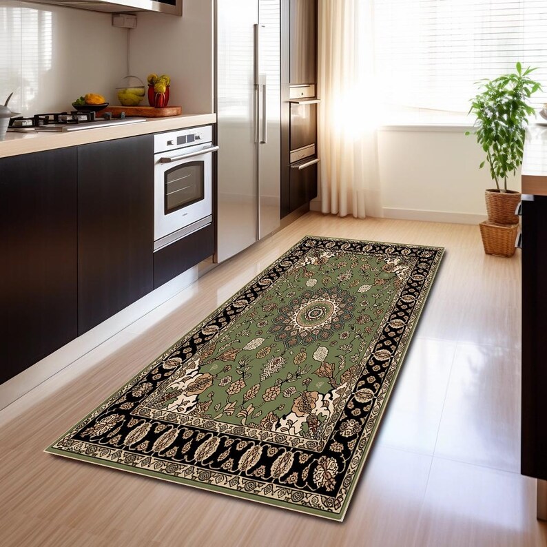 a kitchen with a rug on the floor, a potted plant, and a refrigerator.