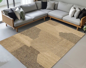 Puede incluir: Una alfombra beige y marrón con un patrón geométrico. La alfombra tiene una textura tejida y está hecha de fibras naturales.