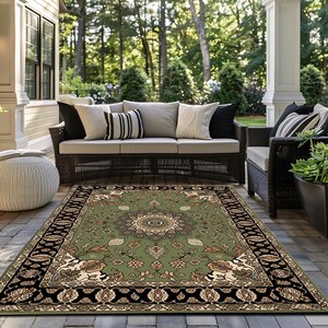 a well-furnished outdoor living area with a large rug on the floor, a comfortable sofa, and wicker furniture. The area is surrounded by lush greenery, creating a serene and inviting atmosphere.