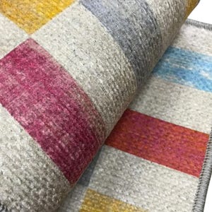 a close-up view of a colorful, multicolored rug or carpet with a geometric pattern.