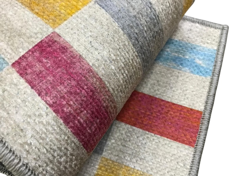 a close-up view of a colorful, multicolored rug or carpet with a geometric pattern.