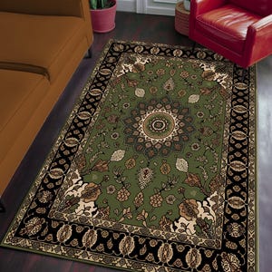 a large, ornate rug with a floral design on a wooden floor. The rug is surrounded by a brown couch and a red chair, creating a cozy and inviting living space.