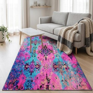 a living room with a gray sofa, a colorful area rug, and a wooden coffee table.