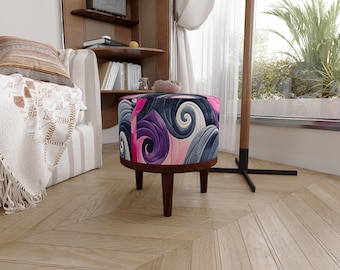 Puede incluir: Un taburete redondo con una tapicería de tela vibrante con un patrón repetitivo de formas arremolinadas en tonos morado intenso, rosa claro y azul oscuro. El asiento se apoya sobre cuatro patas cónicas de madera marrón oscuro.