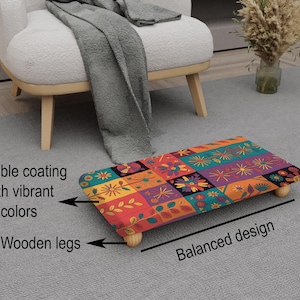 May include: A rectangular footstool with a colorful floral pattern in red, orange, purple, and teal. It has four wooden legs and a durable coating. The text on the image says "Durable coating with vibrant colors", "Wooden legs", and "Balanced design".