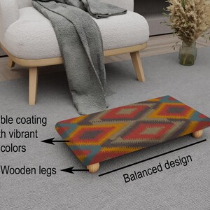 May include: A rectangular footstool with a colorful geometric pattern in red, yellow, blue, and brown. It has a durable coating and wooden legs. The design is balanced.