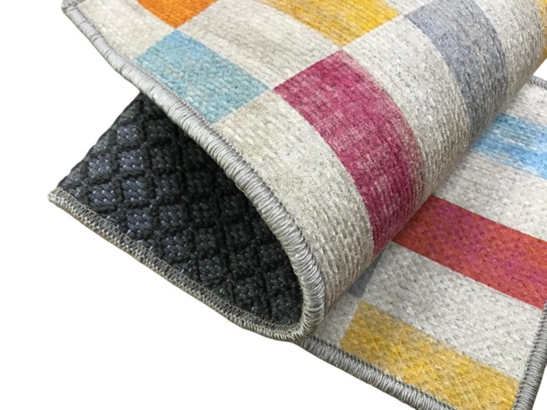 a close-up view of a colorful rug with a geometric pattern, featuring a mix of red, yellow, and blue colors.