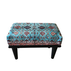 A colorful, patterned ottoman or footstool with a blue and orange design, placed on a white background.