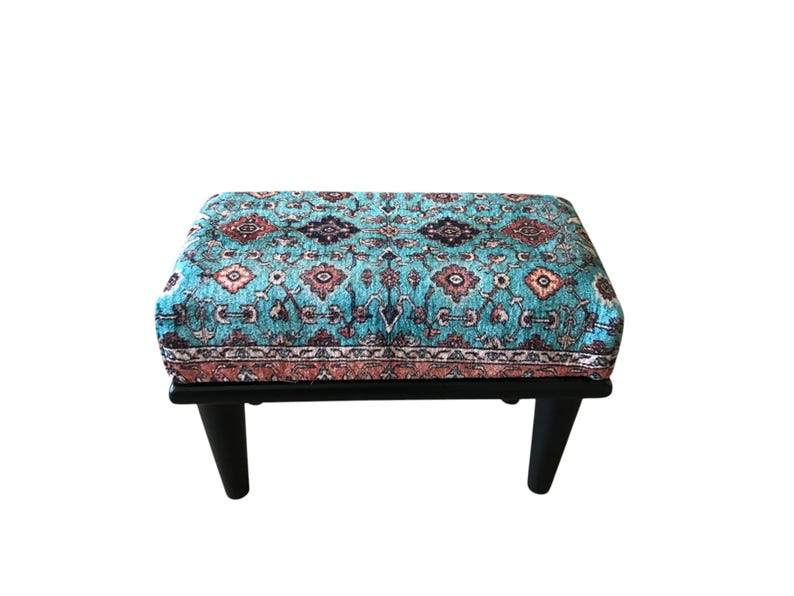 A colorful, patterned ottoman or footstool with a blue and orange design, placed on a white background.