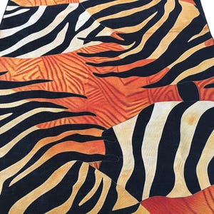 a vibrant and bold pattern of black and orange stripes, resembling the stripes of a zebra or a leopard. The pattern is intricate and detailed, with the stripes varying in size and orientation, creating a visually striking and dynamic design.