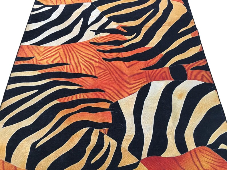 a vibrant and bold pattern of black and orange stripes, resembling the stripes of a zebra or a leopard. The pattern is intricate and detailed, with the stripes varying in size and orientation, creating a visually striking and dynamic design.