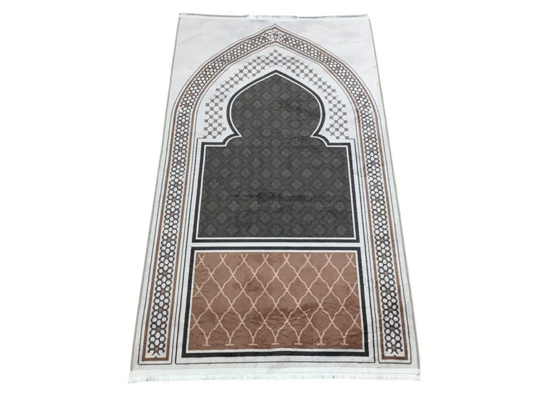 a decorative prayer mat with an intricate design and a geometric pattern.