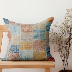 Può includere: Un cuscino patchwork colorato con una varietà di motivi blu, rossi, gialli e marroni. Il cuscino è seduto su una sedia di legno.