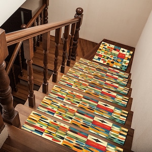May include: A set of colourful geometric patterned stair treads in shades of yellow, blue, red, green, and black. The treads are placed on a wooden staircase with a wooden handrail.