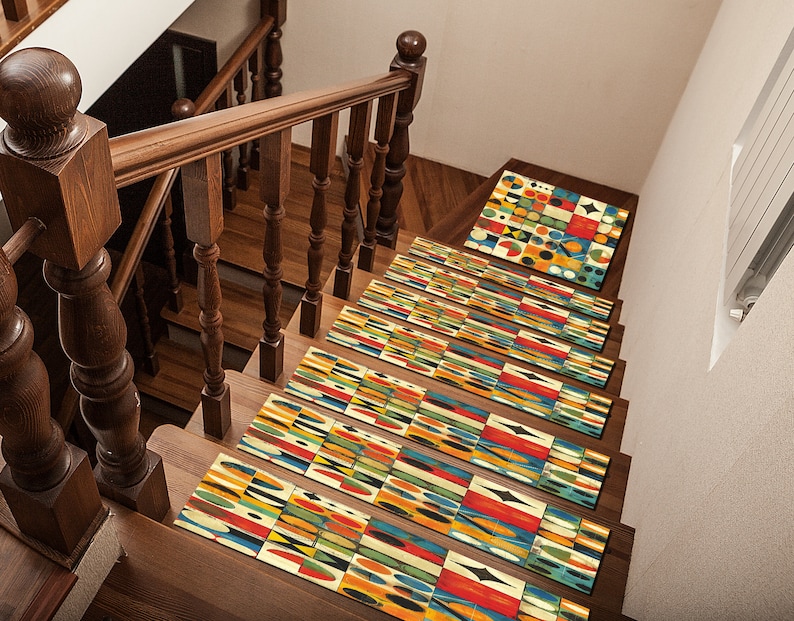 May include: A set of colourful geometric patterned stair treads in shades of yellow, blue, red, green, and black. The treads are placed on a wooden staircase with a wooden handrail.