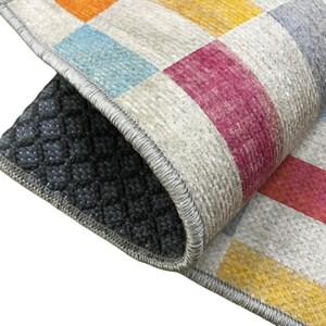 a close-up view of a colorful rug with a geometric pattern, featuring a mix of red, yellow, and blue colors.