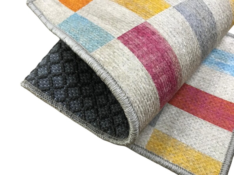 a close-up view of a colorful rug with a geometric pattern, featuring a mix of red, yellow, and blue colors.