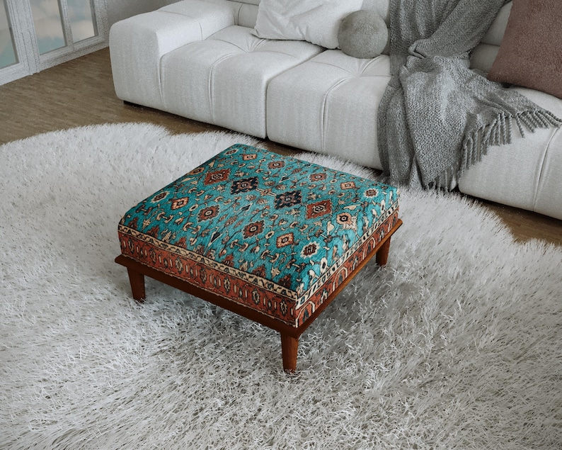 a cozy living room with a plush white rug, a white sofa, and a colorful patterned ottoman on the floor.