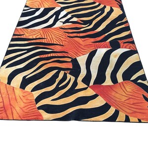 a vibrant and bold zebra print rug with a striking pattern of black and orange stripes.