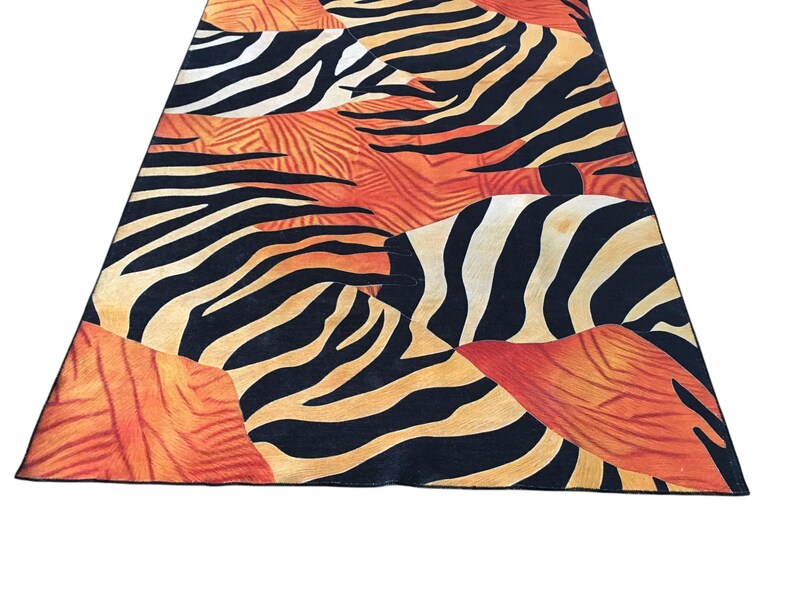 a vibrant and bold zebra print rug with a striking pattern of black and orange stripes.