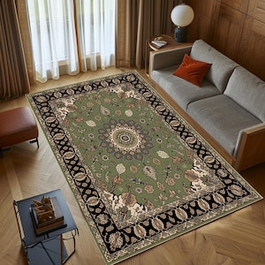 a cozy living room with a large, ornate rug on the floor, a gray sofa, and a wooden coffee table. The room has a warm and inviting atmosphere, with natural light coming in through the window and a lamp providing additional lighting.