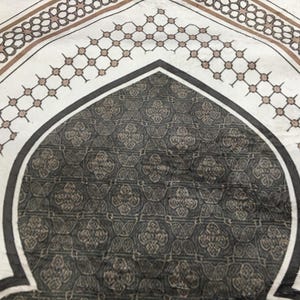 a close-up view of a decorative rug with a geometric pattern in shades of gray and brown.
