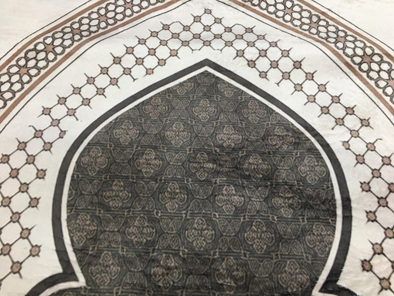 a close-up view of a decorative rug with a geometric pattern in shades of gray and brown.