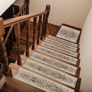 Pode incluir: Um conjunto de seis degraus de escada com padrão bege e marrom com um design floral sutil. Os degraus são colocados em uma escada de madeira com corrimão de madeira escura.
