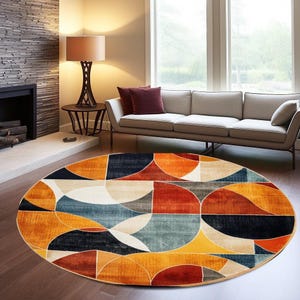 May include: A round area rug featuring a geometric pattern of overlapping semicircles and arcs in a vibrant colour palette of burnt orange, deep navy blue, muted teal, and cream, creating a bold visual design across the entire circular surface.