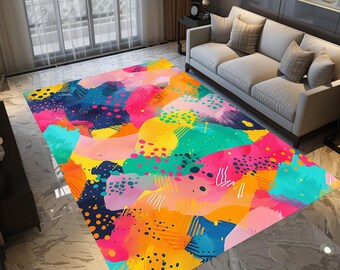 May include: Abstract area rug with a colorful design featuring pink, yellow, blue, green, and black paint strokes and dots.