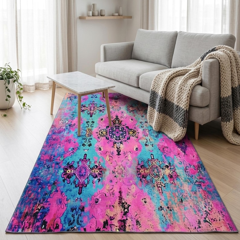 a living room with a gray sofa, a colorful area rug, and a wooden coffee table.