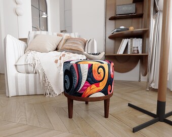 May include: A round ottoman featuring a vibrant, multi-coloured fabric upholstery with swirling patterns in shades of orange, pink, dark blue, and cream. The seat is supported by four short, tapered wooden legs with a dark brown finish.