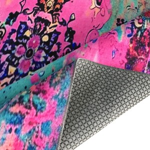 a vibrant, colorful rug with a floral pattern. The rug has a mix of pink, blue, and green colors, creating a visually striking and lively design.