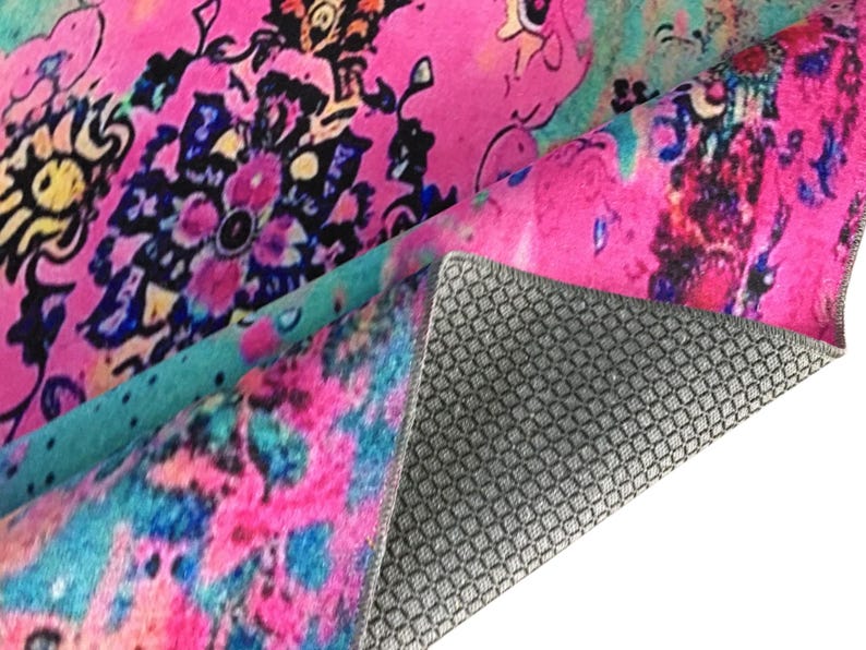 a vibrant, colorful rug with a floral pattern. The rug has a mix of pink, blue, and green colors, creating a visually striking and lively design.
